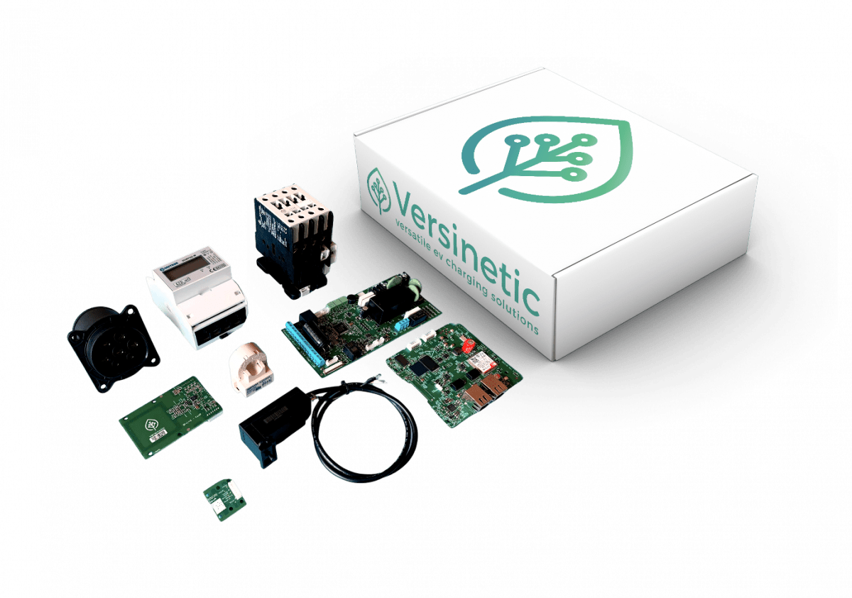 The Versinetic Engineering Specification Kit - a branded kit box with the controller boards, 4-pole contactor, three-phase MID meter, Type 2 socket, RFID reader, sensors and cabling laid out in front